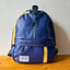An upcycled blue crossbody bag with yellow details from pineapple-fiber leather.