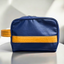 A blue eco-friendly toiletry bag with yellow pineapple-leather details.