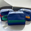 Three toiletry bags made from upcycled airplane seat leather, with details in green, red, and yellow from pineapple-fiber leather.