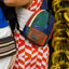 Pineapple leather crossbody bag on a female wearing a red dress.