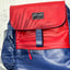 Blue and red backpack with leaf shadow