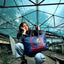 Girl holding a blue tote bag with a cool backdrop. 