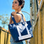 Beautiful model holding a navy blue tote bag made from Southwest Airlines Seats